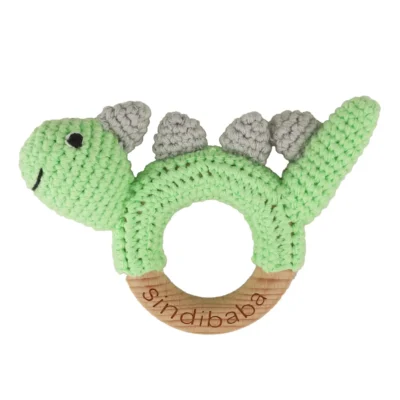 Dinosaur DINO rattle ring with crocheted yarn surface and untreated beechwood ring, front view isolated