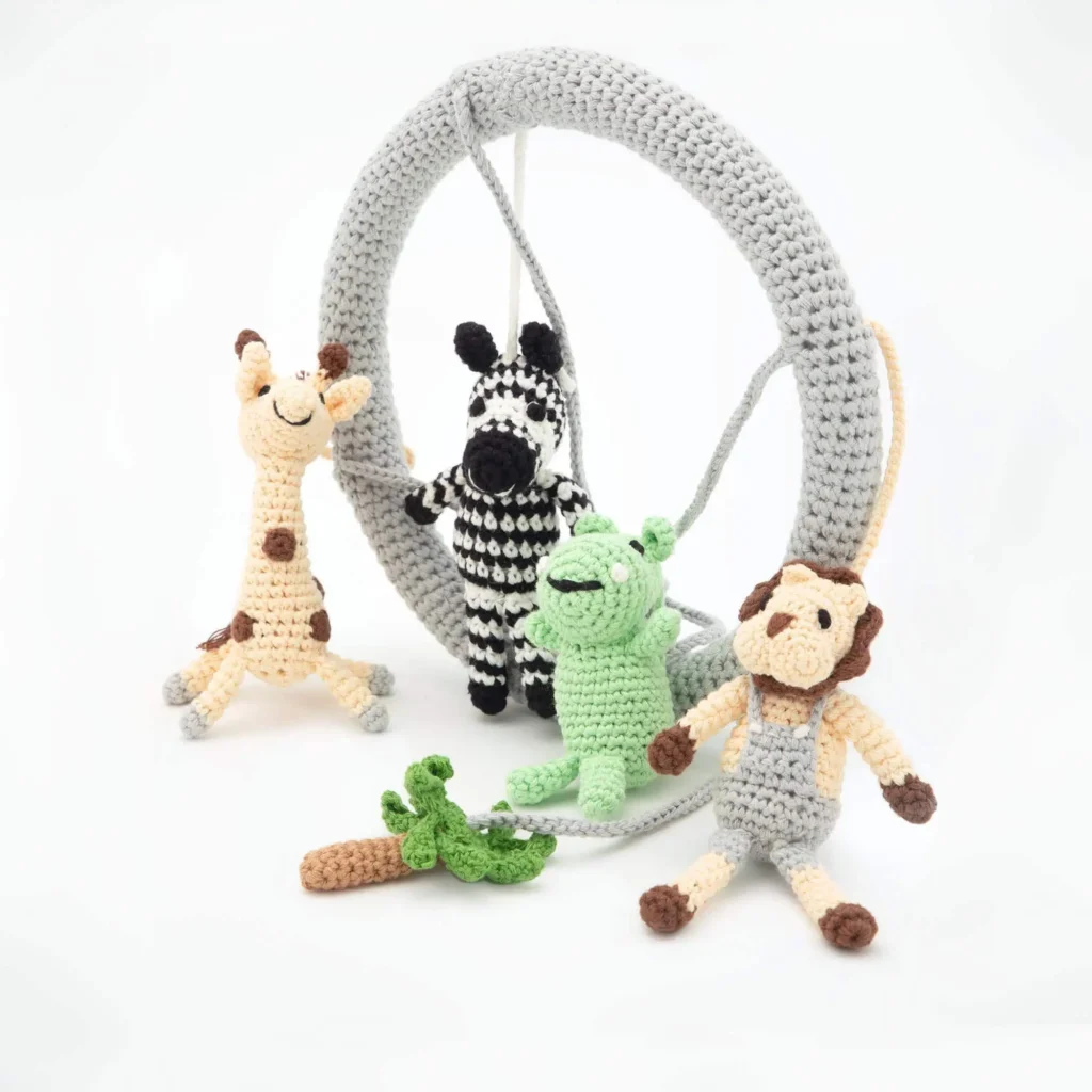 Babymobile Safari 2 als Lifestylearrangement, Mobile-Ring aufgestellt mit Tierfiguren und Baum-Element davor arrangiert