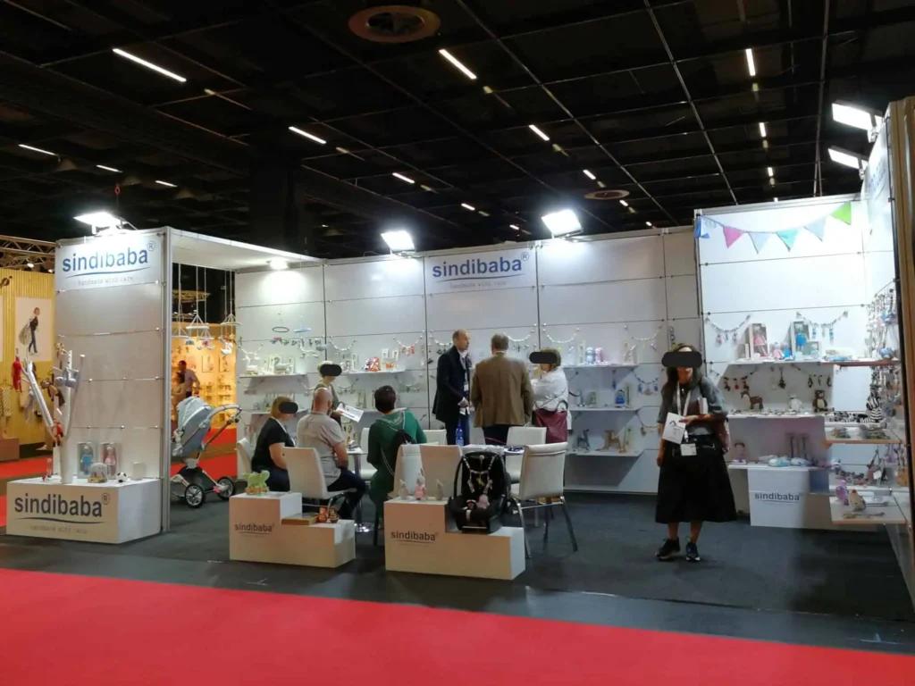 SindiBaba at a trade fair: booth with visitors (faces blurred).