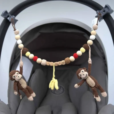 Personalisierte Kinderwagenkette mit Affe-Motiv und Namen Jonah an der Babyschale befestigt.