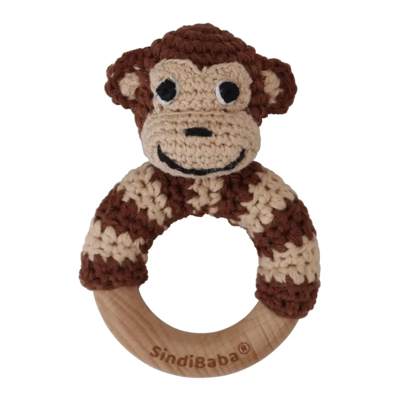 Monkey ring rattle with crocheted yarn surface and untreated beechwood ring, front view isolated