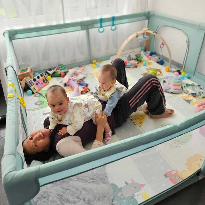 22019 - Spielbogen - Lifestyle-Foto Mutter mit Zwillingen im Laufstall mit Spielbogen und SindiBaba® Spielzeug