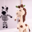 Detailreiche Makroaufnahme der gehäkelten Giraffe und des Zebras im Vordergrund mit weichem Tiefenunschärfe-Hintergrund