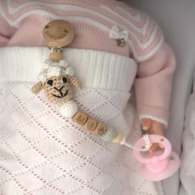 Personalized pacifier chain with sheep motif and the name Mia (flatlay).