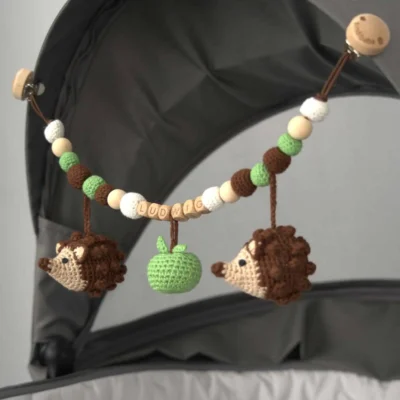 Personalized stroller chain with hedgehog motif and the name Ludwig attached to a stroller.