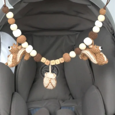 Personalized stroller chain with squirrel motif and the name Janis attached to a Maxi‑Cosi.