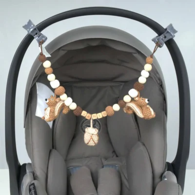 Personalized stroller chain with squirrel motif and the name Janis attached to an infant carrier.