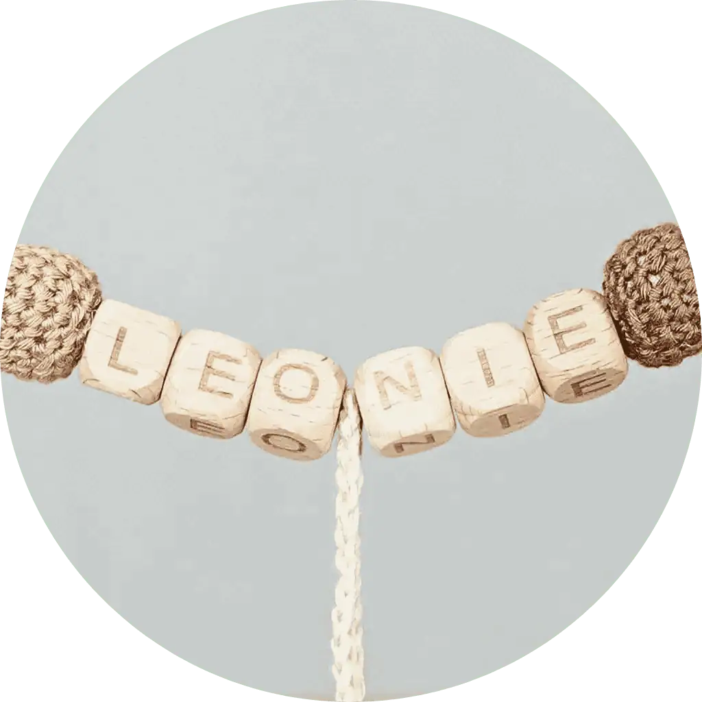 Close-up of name personalization with wooden letter cubes on a SindiBaba stroller chain.
