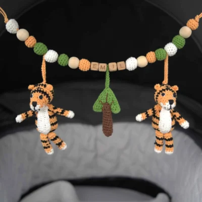 Personalized stroller chain with tiger motif and the name Emil attached to a stroller.