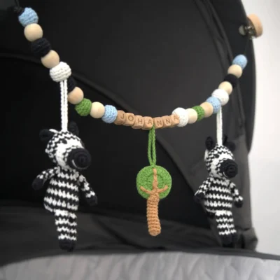 Personalized stroller chain with zebra motif and the name Johanna attached to a stroller.
