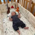 Authentischer Schnappschuss unseres Sohnes im Babybettchen, der von unten gebannt nach den hängenden gehäkelten Mobile-Figuren blickt