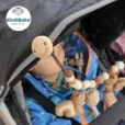 Produktvideo-Thumbnail als Nahaufnahme im Kinderwagen: Der Befestigungsclip mit Markenlogo ist groß im Fokus zu sehen, die Kette verläuft quer vor dem Baby.